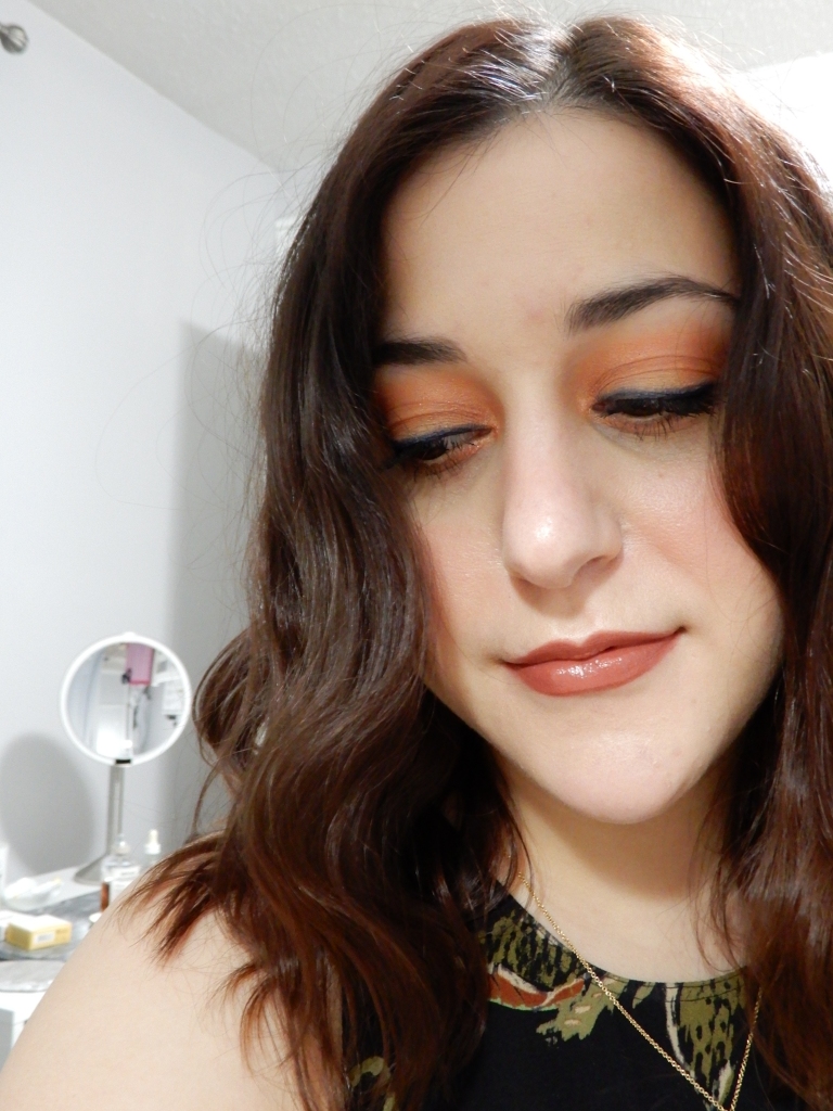 Makeup look with coral eyeshadow and blue liner with a mauve lipstick from nudestix